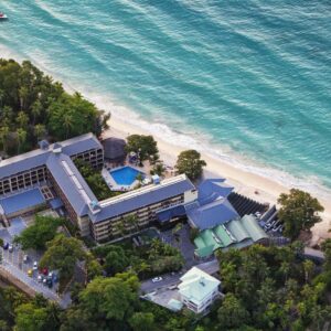 Aerial view of Coral Strand Smart Choice on Beau Vallon beach, with the hotel buildings, pool and gardens behind the sand
