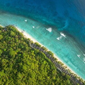 Aerial view of the NIVA Labriz Seychelles villas along the beach and forested coast of Silhouette Island